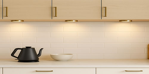 Stylish kitchen featuring under cabinet lights illuminating a wooden countertop with a modern faucet and decor.