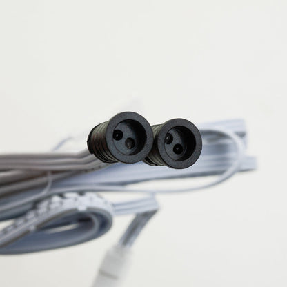 Close-up of a double-headed connector for a sensor switch, featuring two black round sockets and gray cable.