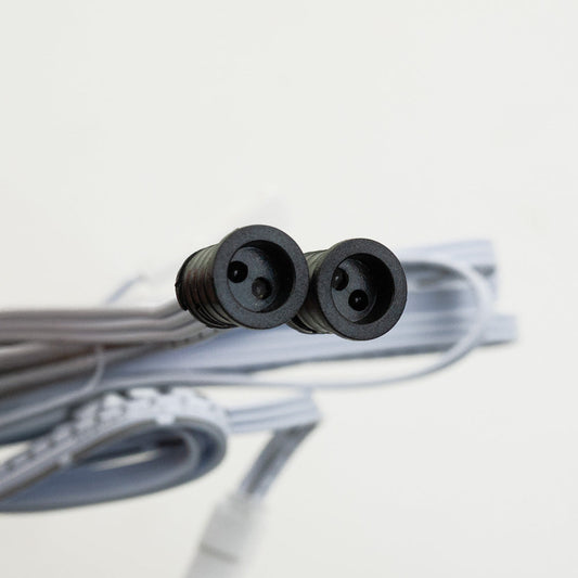 Close-up of a double-headed connector for a sensor switch, featuring two black round sockets and gray cable.